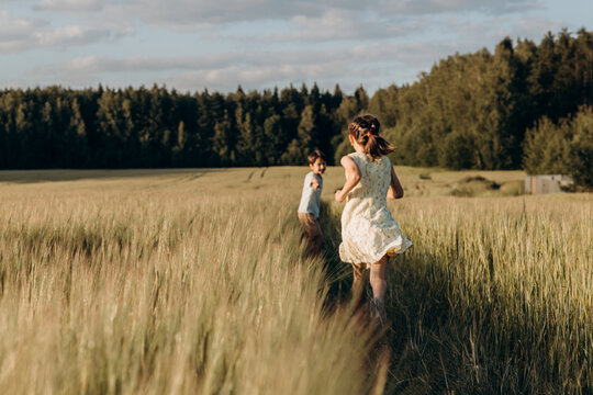 Kids are running in the field in summer  - Powered by Adobe