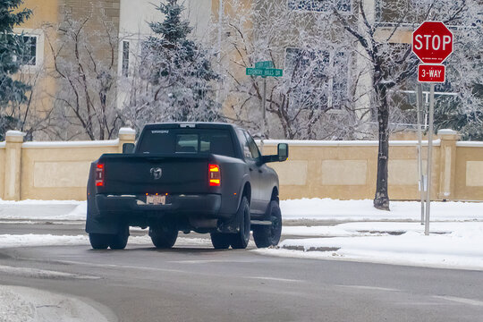 Calgary, Alberta, Canada. Feb 9, 2024. A close up to a Dualie 6x4 truck, featuring dual rear wheels, traversing wintry road conditions.