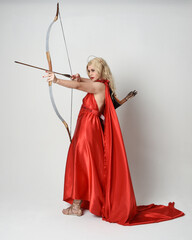 Full length portrait of  blonde model dressed as mythological fantasy goddess in flowing red silk...