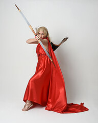 Full length portrait of  blonde model dressed as mythological fantasy goddess in flowing red silk...