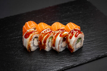 Sushi, Philadelphia rolls with salmon and eel. On a black background.