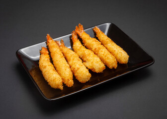 Tempura shrimp fried in breadcrumbs. On a black background.