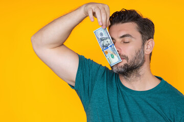Man hold money on yellow studio isolated background. Portrait of rich man with money dollar bills....