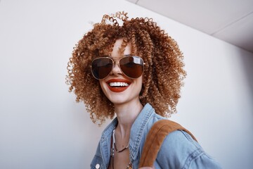 Joyful Lady with Afro Hairstyle, Laughing and Smiling in Bright Yellow Sunglasses on a Stylish White Background