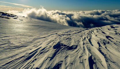 Snow covered mountains and frozen snow shapes modeled by wind in the Transylvanian Alps