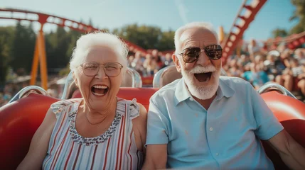 Papier Peint photo autocollant Parc dattractions Senior couple having fun on a roller coaster ride in a theme park. 