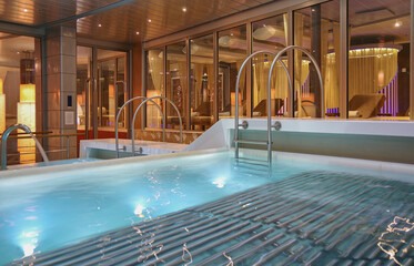 Indoor swimmingpool with hot tub whirlpool inside thermal suite in spa or wellness area onboard...