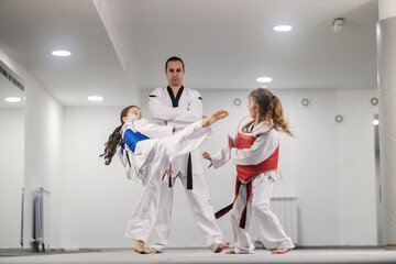 Two taekwondo kids in sparring at taekwondo class at martial art school.