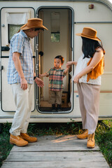 An Asian multiracial family with children are camping in nature on a road trip. Dad and mom daughter and son in the woods in the summer. Selective focus