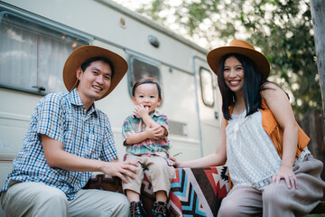 An Asian multiracial family with children are camping in nature on a road trip. Dad and mom daughter and son in the woods in the summer. Selective focus - obrazy, fototapety, plakaty
