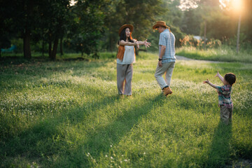 Fototapeta premium happy harmonious Asian family outdoors concept, Asian mother and son have activities happy fun together on holidays, grass land with sunlight