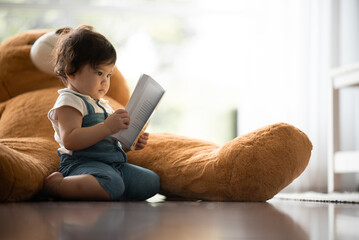 Smiling and happy cute and adorable Caucasian child looking to camera, Portrait of little toddler boy reading book and with joyfully and happiness. Concept of childhood, motherhood bonding health care