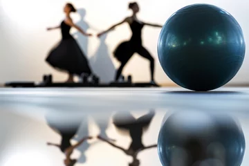 Foto op Plexiglas Dansschool pilates ball in foreground, dancers reflection in background