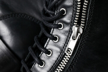 Black leather background. Grunge autumn clothing. Winter fashion texture. Closed fastener zipped...