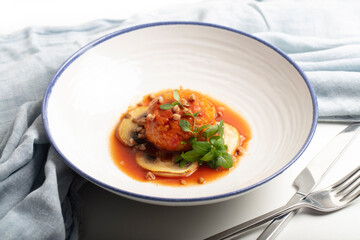 Braised buckwheat and minced meat patty in tomato-basil sauce, served with mushrooms and microgreens. Trendy modern cuisine, nutritious grain-based dish. Healthy eating concept