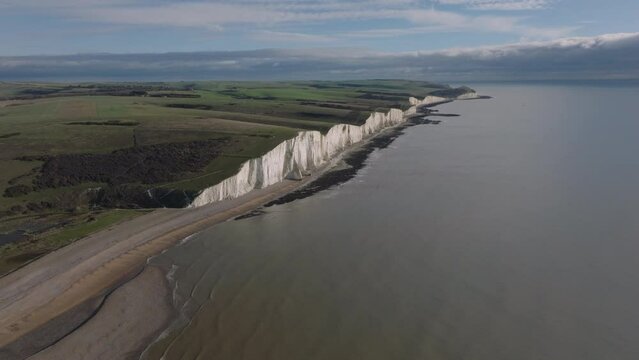 Dolly back aerial shot of the seven sisters chalk cliffs and cuckmere heaven