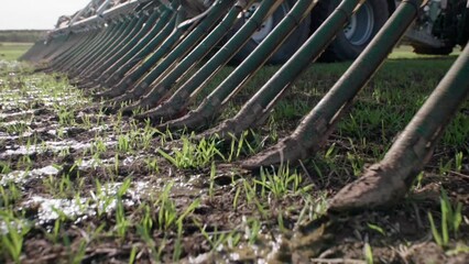 Liquid manure spreader releasing slurry on field close up slow motion