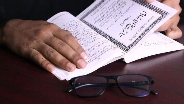 A boy read an Urdu historical book of Islam. urdu manuscript book study concept. book with glass educational concept.