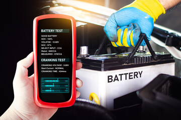 Battery tester in a car mechanic hand for testing battery voltage and battery health , Car...
