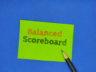 A picture of green paper and a pencil with the words "Balanced Scoreboard" written on it. Business themed picture concept.