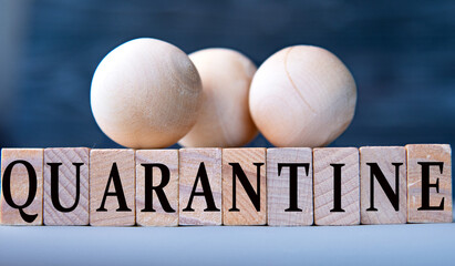 QUARANTINE - word on wooden blocks on dark blue background