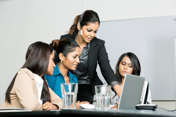 Indian colleagues working around a laptop