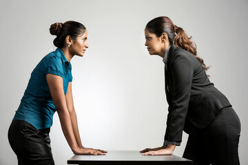 Angry Indian business women staring at each other.
