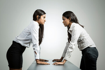 Angry Indian business women staring at each other.