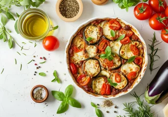 Fotobehang Eggplant tomatoes mozzarella casserole with vegetables olive oil herbs and seasonings on white ceramic dish © The Big L