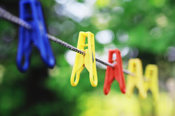 Dry clothes outside. Clothes on a rope. Clothespins on a clothesline in summer. - obrazy, fototapety, plakaty