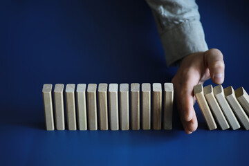 Closeup thick domino wood block in a row stop the falling, be stable in crisis, business solution...