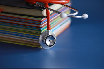 stethoscope on stack of medical guide book for doctor learning treatment at hospital.