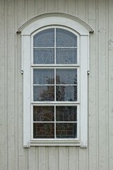 White framed window on old light green painted wood wall.