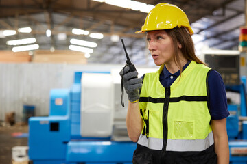 female worker talking on walkie talkie in the factory