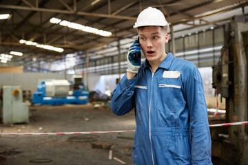 technician or engineer talking on smartphone and feeling excited in the factory