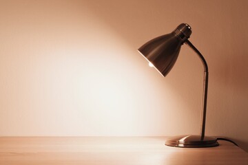 Lamp on the desk top, space for text. Trendy color of the year 2024 - peach fuzz