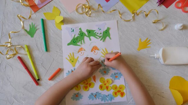 Child making homemade greeting card. little girl making card for mom with flowers from paper as gift for Mothers day, Birthday or Valentines day . Arts  crafts concept.