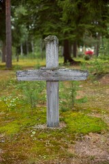Weathered wood grave cross in cemetery.