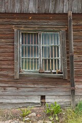 Window on a dilapidated and run down house with weathered planks.