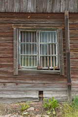 Obraz premium Window on a dilapidated and run down house with weathered planks.