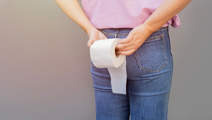 Woman hand holding her bottom and tissue or toilet paper roll. Disorder, Diarrhea, Constipation.