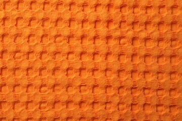 Texture of orange knitted fabric as background, top view