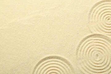 Fototapeta na wymiar Zen rock garden. Circle patterns on beige sand, top view