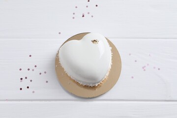 St. Valentine's Day. Delicious heart shaped cake and confetti on white wooden table, top view