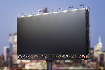 Blank black billboard on cityscape background at evening, perspective view. Mock up, advertising concept