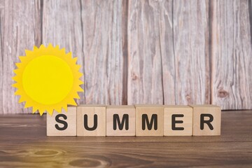 Summer season word typography in wooden backdrop with sun design.	