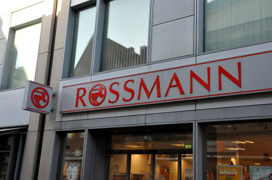 Rossmann: Rote Schrift mit Logo der Drogeriemarktkette über dem Geschäftseingang.