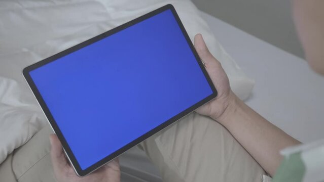 Asian Man looking To Tablet with Blue Screen And Enjoy