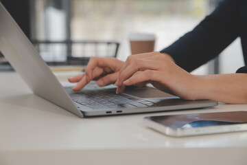 Asian Businesswoman Using laptop computer and working at office with calculator document on desk,...
