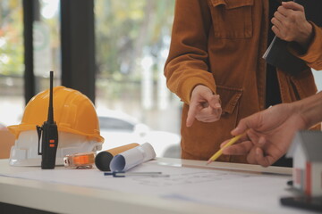 Male and Female Industrial Engineers in Hard Hats Discuss New Project while Using Laptop. They Make...